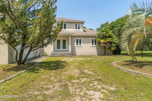 rear view of house featuring french doors and a lawn