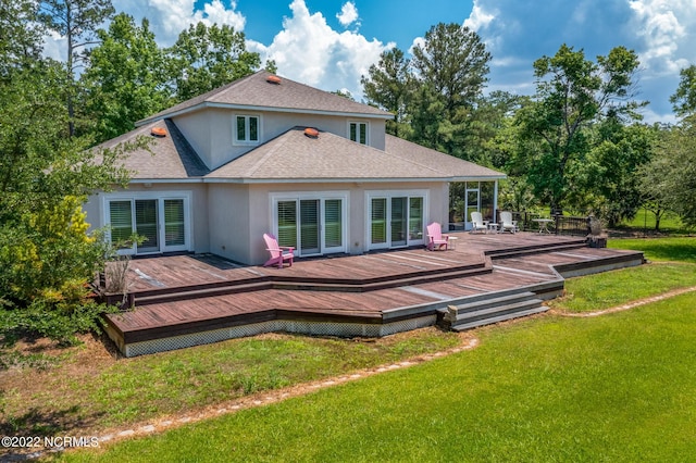 rear view of property with a wooden deck and a lawn