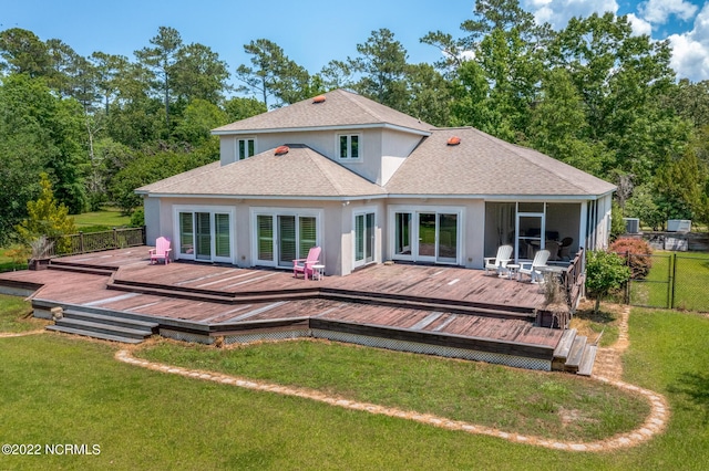 rear view of house featuring a deck and a yard