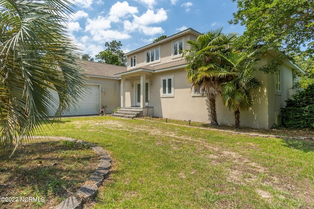 back of property featuring a yard and a garage