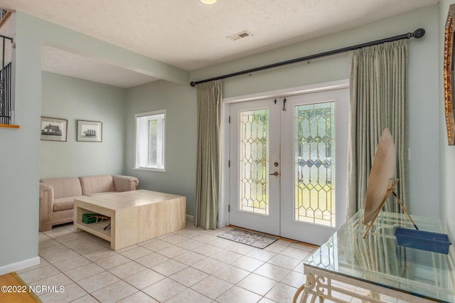 doorway to outside with light tile floors and french doors