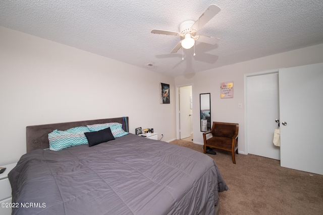 bedroom with a textured ceiling, ceiling fan, and light colored carpet