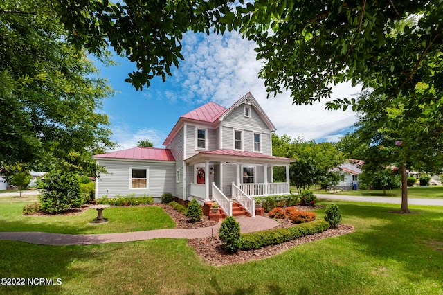 view of front of property featuring covered porch and a front lawn