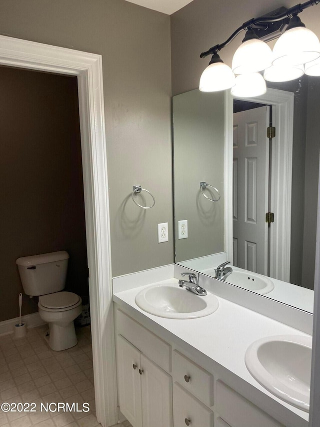 bathroom featuring double sink vanity, toilet, and tile floors