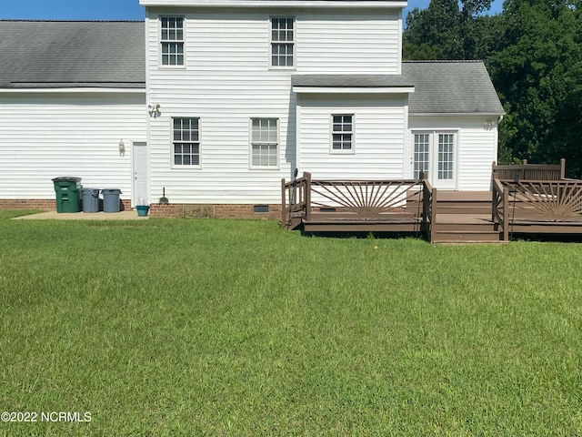 back of property featuring a deck and a yard