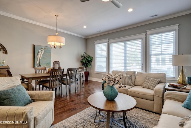 living room with dark hardwood / wood-style floors, ornamental molding, and ceiling fan with notable chandelier