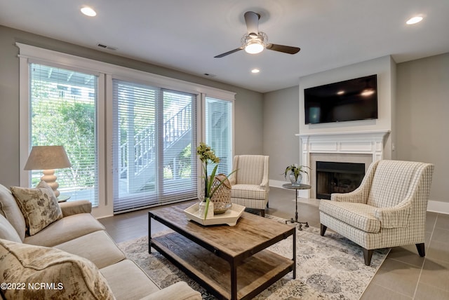 tiled living room with plenty of natural light and ceiling fan