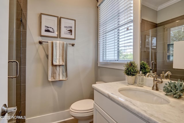 bathroom featuring ornamental molding, toilet, vanity, and a healthy amount of sunlight