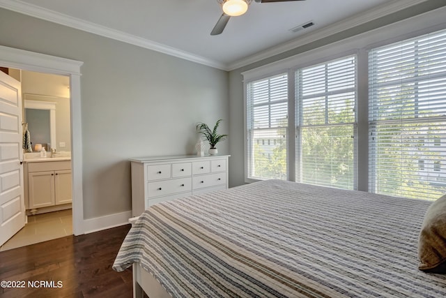 bedroom with ceiling fan, dark wood-type flooring, multiple windows, and ensuite bath