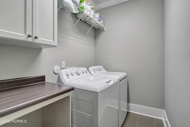 laundry area featuring cabinets, dark tile floors, crown molding, and washer and dryer