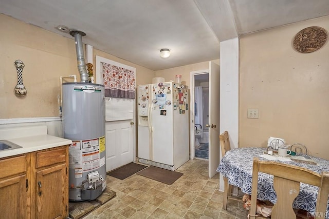 interior space featuring light tile floors, water heater, and white refrigerator with ice dispenser