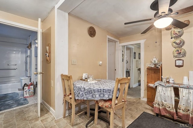 dining space with ceiling fan and light tile floors