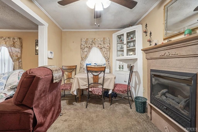 sitting room with a textured ceiling, crown molding, ceiling fan, and carpet floors