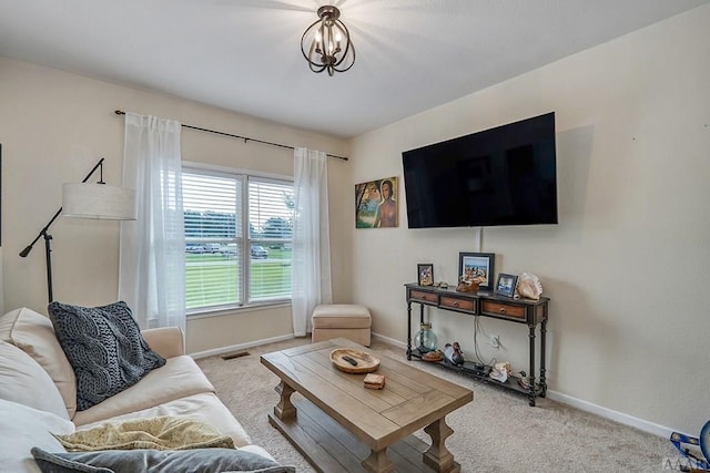 carpeted living room with a notable chandelier