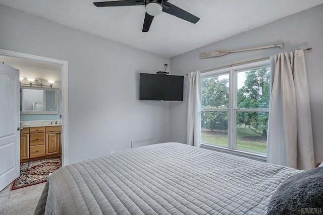 bedroom featuring multiple windows, vaulted ceiling, ceiling fan, and ensuite bathroom