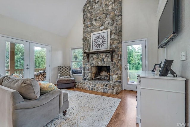 living room with french doors, plenty of natural light, hardwood / wood-style floors, and a fireplace