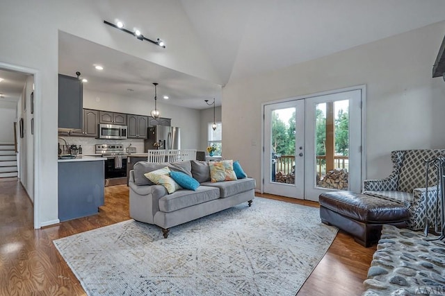 living room featuring french doors, lofted ceiling, and hardwood / wood-style flooring