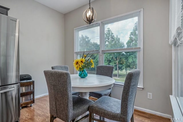 dining space featuring light hardwood / wood-style flooring, a chandelier, and plenty of natural light