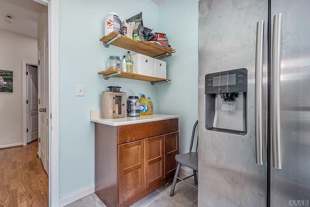 bar with stainless steel fridge with ice dispenser and light hardwood / wood-style floors