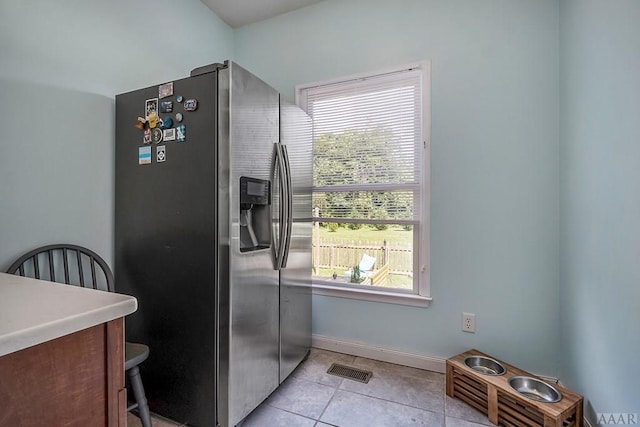 kitchen featuring stainless steel fridge and light tile floors