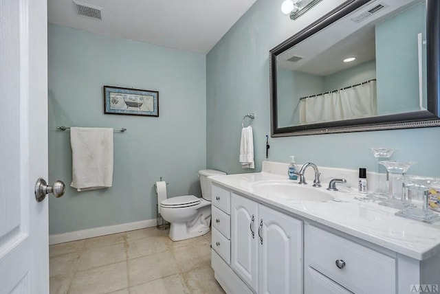 bathroom featuring toilet, vanity, and tile flooring