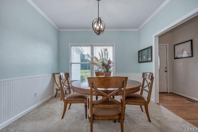 dining area featuring a notable chandelier, crown molding, and light wood-type flooring