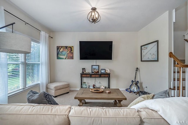 carpeted living room with an inviting chandelier