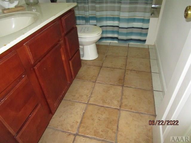 bathroom featuring toilet, tile flooring, and vanity