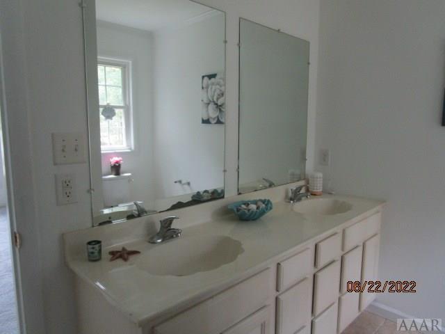 bathroom featuring vanity with extensive cabinet space and dual sinks