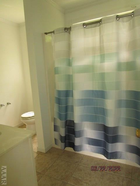 bathroom with toilet, tile floors, vanity, and crown molding