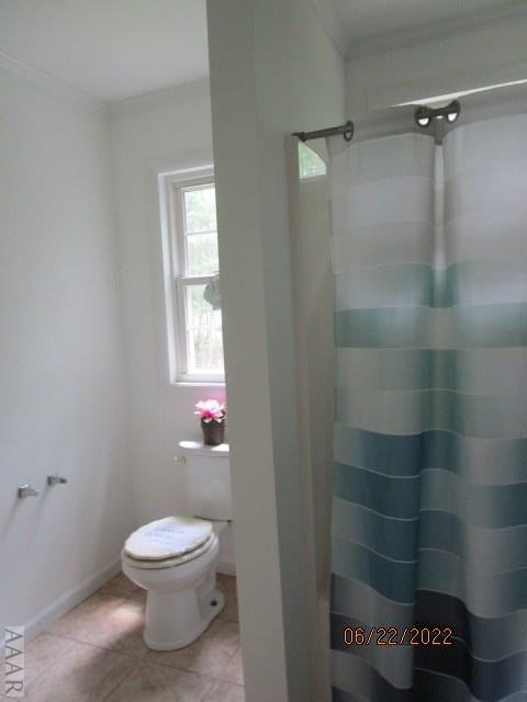 bathroom with ornamental molding, tile floors, and toilet