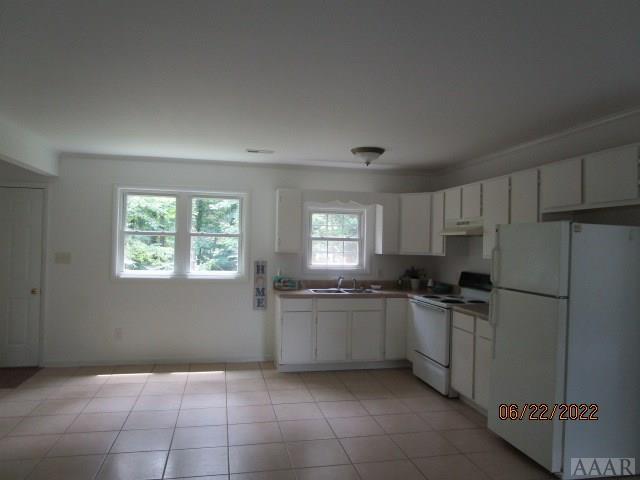 kitchen with white cabinets, white appliances, sink, and light tile floors