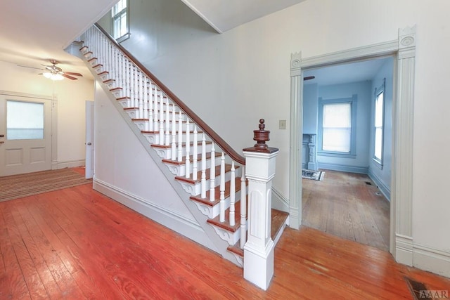 stairs featuring ceiling fan and light wood-type flooring