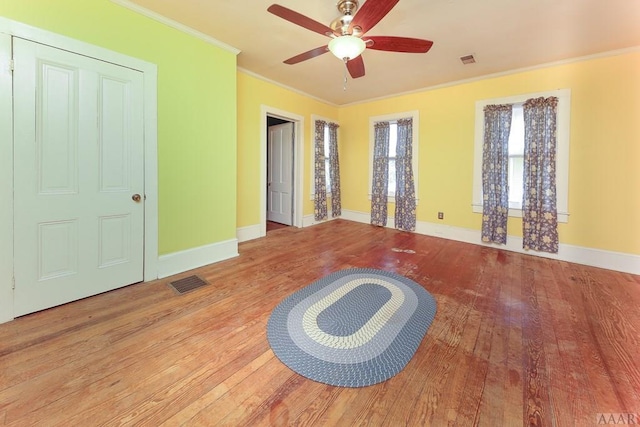 empty room with crown molding, ceiling fan, and light hardwood / wood-style flooring