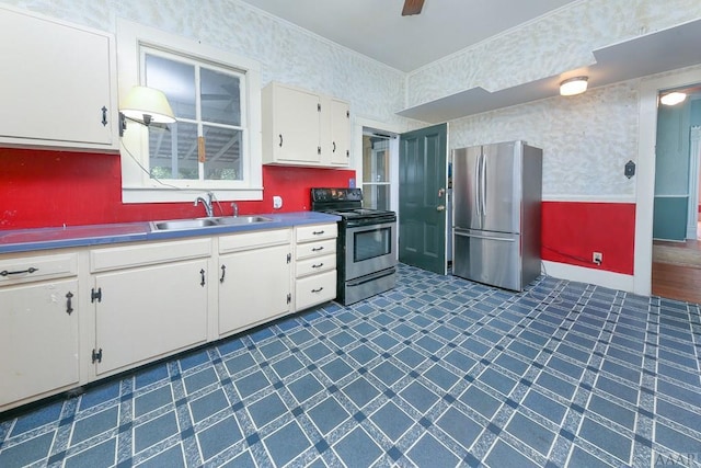 kitchen featuring dark tile flooring, stainless steel appliances, white cabinets, and sink