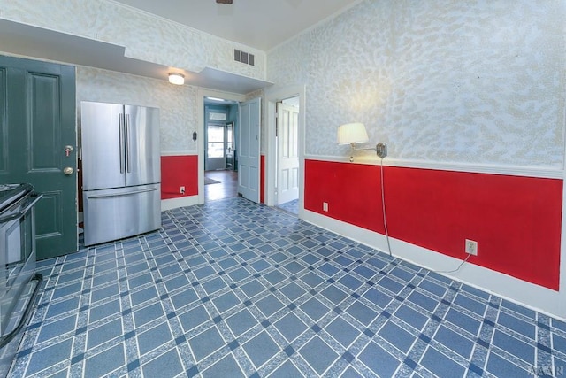 kitchen with stainless steel fridge, stove, and dark tile flooring