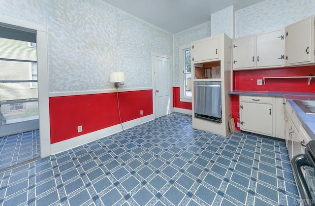 kitchen featuring sink, range, dark tile floors, and white cabinets