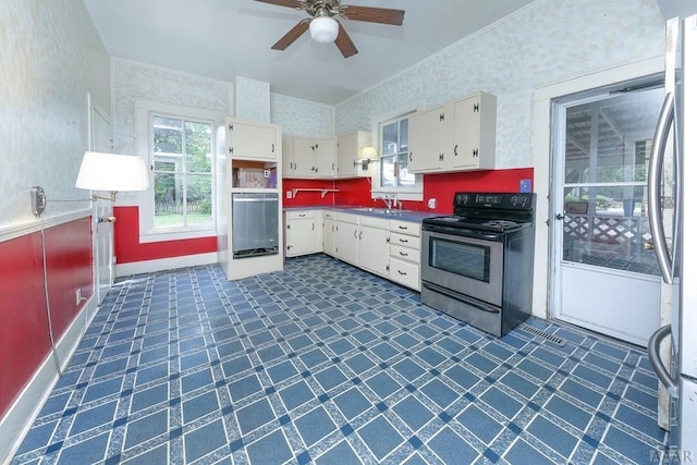 kitchen with white cabinets, ceiling fan, and stainless steel appliances