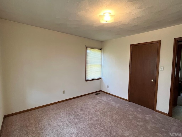 unfurnished bedroom with dark colored carpet