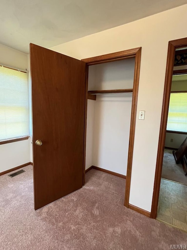 unfurnished bedroom with dark colored carpet and a closet