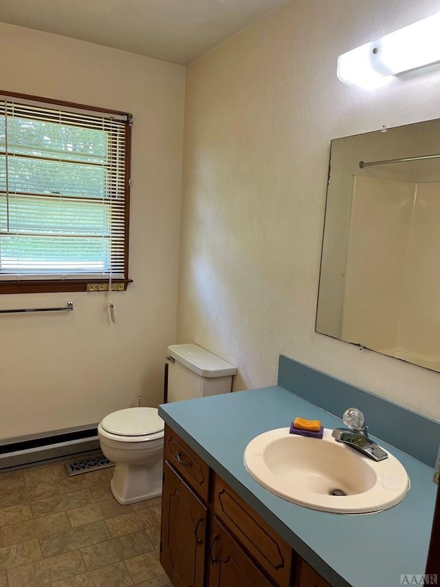 bathroom featuring toilet, vanity, a baseboard radiator, and tile flooring