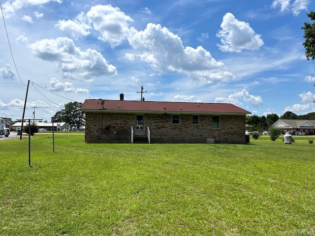 rear view of property featuring a yard