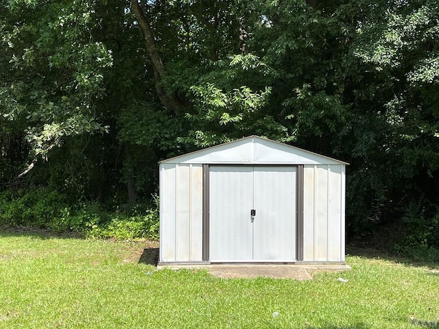 view of outdoor structure featuring a lawn