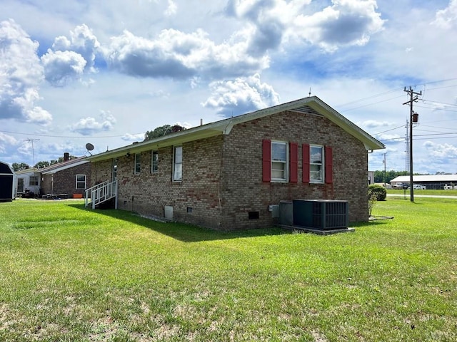 exterior space featuring central AC and a lawn