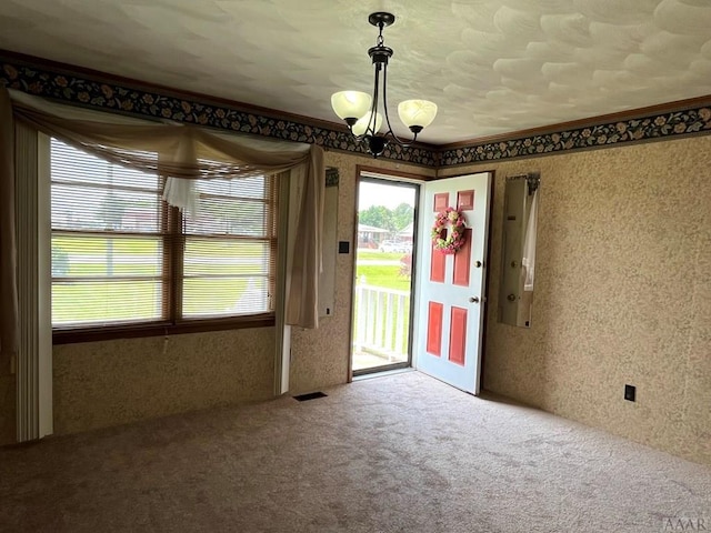 carpeted empty room with a wealth of natural light and a chandelier