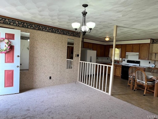 kitchen featuring a chandelier, white range with electric stovetop, dark colored carpet, and pendant lighting