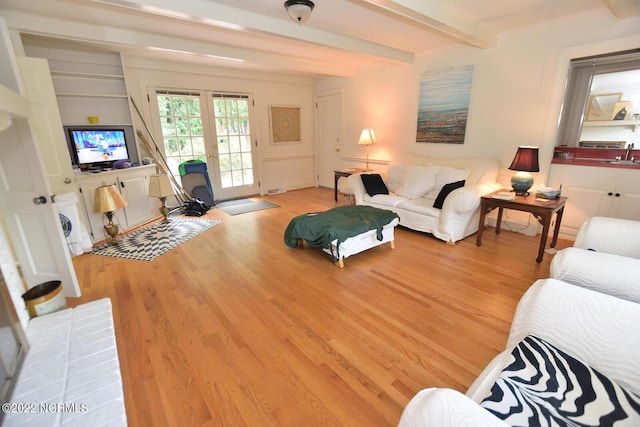 living room featuring beam ceiling, light hardwood / wood-style floors, french doors, and sink