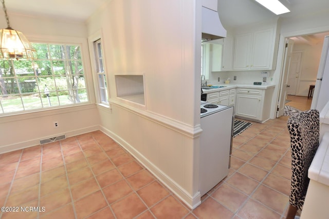 kitchen featuring a chandelier, light tile flooring, white cabinetry, white electric stove, and sink