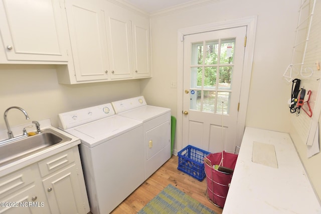 laundry room with crown molding, cabinets, independent washer and dryer, and light wood-type flooring