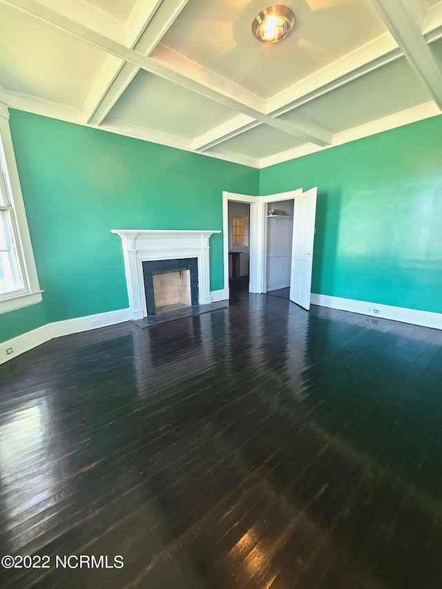 unfurnished living room featuring beam ceiling, dark hardwood / wood-style flooring, and coffered ceiling